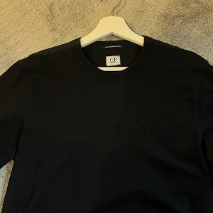 Svart långärmad tröja C.P. Company - Svart långärmad tröja från C.P. Company med diskret broderad logga på bröstet. Andvänd fåtal gånger!