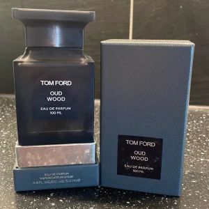 Tom Ford Oud Wood EdP 100ml - Tom Ford Oud Wood Eau de Parfum 100 ml. Flaskan är mörkgrå och fyrkantig med en elegant silverdetalj på toppen. Kommer i originalförpackning med matchande mörkgrå kartong. En lyxig och ikonisk doft med exklusiv känsla. Kvitto finns 