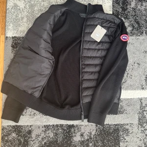 Svart jacka från Canada Goose - Säljer en snygg svart cardigan från Canada goose jätten fin och unik! Storleken är L och skicket är som nytt. Priset är diskuterbart. Vid några som helst frågor eller funderingar, tveka inte hör av dig! Nypris: 8475kr.