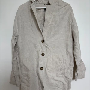 Beige kappa från Lindex - Säljer en beige kappa från Lindex i storlek XS men skulle säga att den passar mer som S/M. Jackan är lite längre i längden. Säljer då den inte kommer i användning.