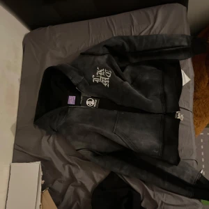 Svart hoodie med dragkedja - Säljer en svart Lukamachain hoodie. Den har en bekväm passform och är perfekt för olika stilar. Den är distressed och huvan passar mycket fint 