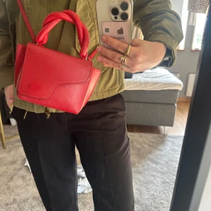 ATP väska mini röd - Mini ATP väska i röd snygg färg, m twistade handtag och avtagbar axelrem! Nypris 3900kr säljes för 1999kr, nyskick och knappt använd! 