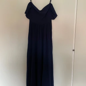 Mörkblå balklänning  - Elegant mörkblå balklänning som har använts 1 gång. Klänningen går långt ner till fot anklarna och är insydd 1 dm över bysten. På sidan finns det en dragkedja
