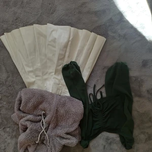 Klädpaket  - Tjocktröja, lapp L mer en S. Något sliten. Grön topp S. Kjol M mer en S, liten fläck på insidan 