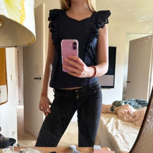 Mörkblå topp med volangdetaljer - Säljer en mörkblå topp från Lindex med volangdetaljer på axlarna. Toppen är ärmlös och har en rund halsringning. Perfekt för en stilren och chic look. Köpt för 250 kr, använd men mycket bra skick ändå. Skriv för fler bilder eller vid intresse.