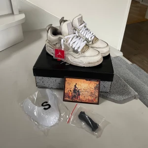 air jordan 4 - pure money - Säljer ett par Nike Air Jordans Retro i vit och grå. Skorna har en klassisk design med snörning och rund tå. Perfekta för sneaker-entusiaster som vill ha en stilren look. som ni kan se så är de ganska använt, men det går att snygga upp skorna.