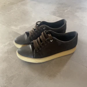 Lanvin cap toe - Snygga bruna sneakers från Lanvin med en stilren design. Skorna har en rund tå och snörning framtill. De har en kontrasterande vit sula som ger en cool look. Perfekta för en avslappnad stil.