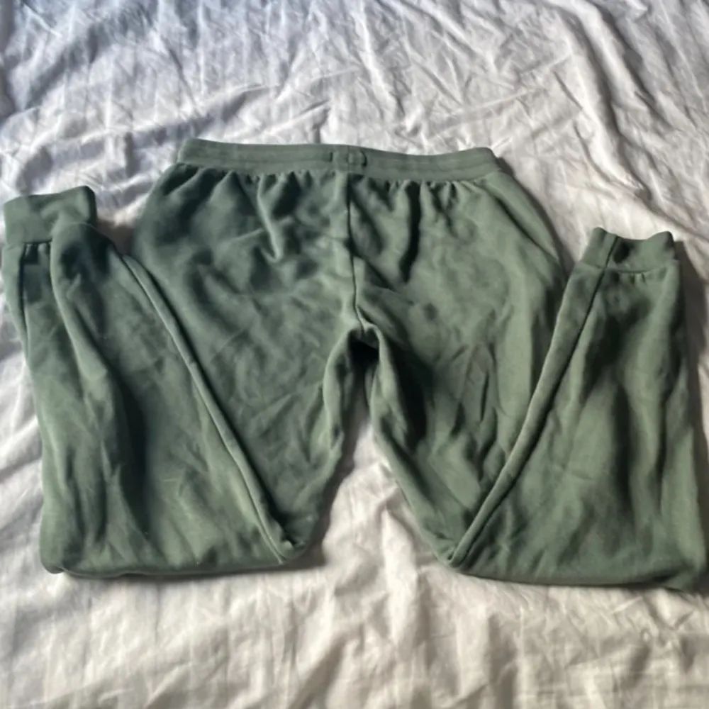 Säljer ett par gröna mjukisbyxor från U.S. Polo Assn. med broderad logga på benet. Byxorna har en bekväm passform med resår och snörning i midjan samt muddar vid bensluten.. Farkut & Housut.