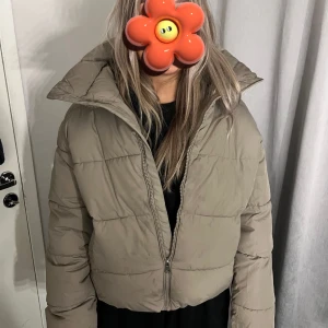 Beige pufferjacka - Säljer en beige pufferjacka med dragkedja. Jackan har en hög krage, och är i storlek S 
