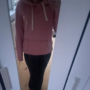 Rosa hoodie från Hollister - Säljer en mysig rosa hoodie från Hollister med vit dragsko och känguruficka. Perfekt för en avslappnad stil. 💖
