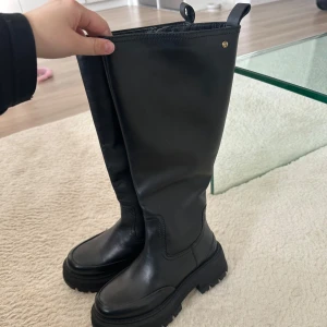 Svarta skinnstövlar med grov sula - Snygga svarta stövlar i skinn med en robust och grov sula. Perfekta för en stilren look med en touch av edge. De har en rund tå och är lätta att matcha med olika outfits.