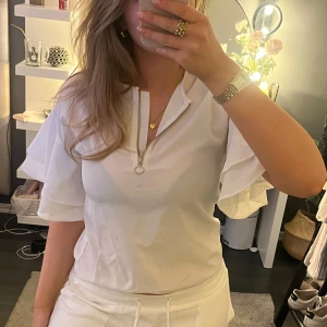 Vit blus med volangärmar - Säljer en stilren vit blus med volangärmar och v-ringning. Har tyvärr två små fläckar som säkert går bort i tvätten💌