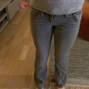 Grå jeansbyxor - Snygga grå jeansbyxor från Gina tricootmed normal passform och klassisk femficksdesign. Byxorna har en knapp och dragkedja framtill samt dekorativa sömmar på bakfickorna.