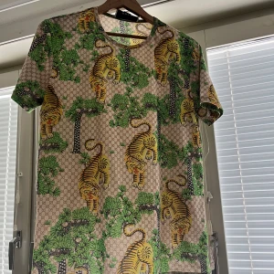 Rare Gucci tröja med tigrar - Rare gucci tröja med tigrar o lite grönt på sig. XL men passar som M, specifika mått (söm till söm): krage 17cm, axlar 45cm, ärm-bröst 40cm, midja 52cm
