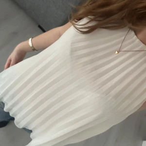 Vit ärmlös blus - Säljer en stilren vit blus med plisserad design. Den är ärmlös och har en luftig passform, perfekt för varma dagar. Blusen är enkel att matcha med både jeans och kjol.💓💓💓passar de flesta storlekarna 