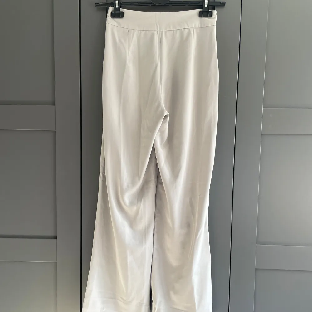 Kostymbyxor ”Adriana” från BikBok i storlek XS. Grå/beige i färgen. De är avkortade med hjälp av uppfållningsband (band som stryks på) för att passa mig som är 160cm, men detta kan tas bort för att få full längd igen. . Farkut & Housut.