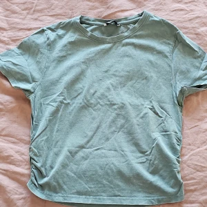 Grön t-shirt från Sister - Säljer en enkel och stilren grön t-shirt från Sister. Den har en rund halsringning och korta ärmar, perfekt för en avslappnad look. T-shirten är gjord i ett mjukt bomullsmaterial som känns skönt mot huden.