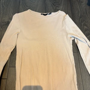 Beige långärmad tröja från 157 - Säljer en stilren beige långärmad tröja från 157. Perfekt för en enkel och avslappnad look. Tröjan har en rund halsringning och är gjord i ett mjukt material.