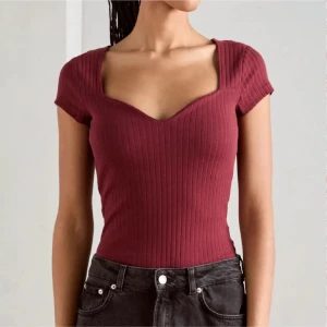 Vinröd ribbad topp från Anna Field - Vinröd ribbad topp från Anna Field med korta ärmar och snygg sweetheart-urringning. Toppen är figurnära och har en modern, croppad känsla. Perfekt att styla med jeans eller kjol för en trendig look.