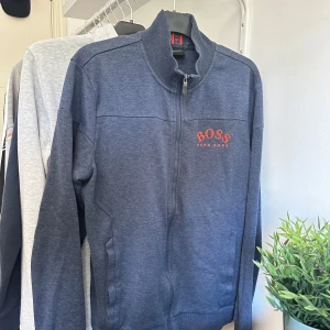 Mörkgrå zip från Hugo Boss - En väldigt fin mörkgrå Hugo boss zip tröja. Köpt från Hugo boss för ett par år sedan (när de såldes). Tröjan är inte använd mer en 3 gånger. Bara blivit liggandes. Nypris 1500