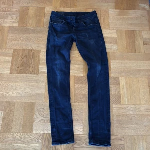 Dondup George jeans - Hej säljer mina mörkblå dondup jeans. Jeansen är i ett bra skick men ganska mycket använda skulle säga 8/10. Dem har inga stora defekter och inga som syns dock inne i vänstra fickan är det ett litet hål ( fråga om bild). Jeansen är i storlek 30 passar Ish 165-175. Dem är för små för mig därför säljer jag dem. Frågor och funderingar hör av er 💸😀