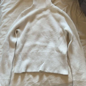 Vit polotröja från Zara i stickat material - Mysig vit polotröja från Zara i stickat material. Tröjan har ribbade detaljer vid krage, ärmslut och nederkant. Långärmad och med hög polokrage som man kan vika ner. Fint skick 🌸