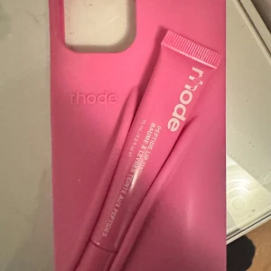Rhode Peptide Lip Tint rosa - Rhode skal och Rhode Peptide Lip Tint i en snygg rosa tub, 10 ml. Ger läpparna en lätt tint och återfuktar med peptider. Perfekt för dig som vill ha glansiga, mjuka läppar med en hint av färg. Kommer i en modern, stilren förpackning. 