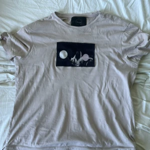 Limitato T-shirt Beige - En beige limitato t-shirt med Muhammad Ali tryck. Tröjan är i använt skick, nypris ca 2000