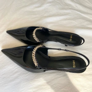 Svarta pumps med kedjedetalj från Mango - Snygga svarta pumps från MNG med spetsig tå och låg klack. Helt nya, aldrig använda! Nypris: 599kr