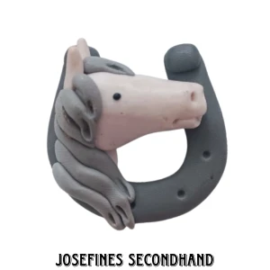 Häst brosch - Handgjord brosch av lera i form av en häst och hästsko. Köpt secondhand. Är i fint skick. Skickas med brev, frakt 15 kr. Frii frakt vid köp av 3 eller fler smycken/smink prylar