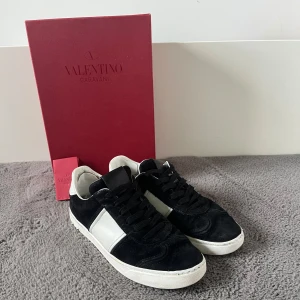 Valentino Garavani svartvita sneakers - Svarta Flycrews! Säljer ett par riktigt schysta dojjor som tyvär blivit urväxta, storlek 39 men passar upp mot 40,5 några defekter då dem är slitna som man ser på bild 5 och några bitar är borta, Valentino kort och box medföljer lådan har en liten defekt men den syns bara om man kollar nogrant (hörnet uppe åt höger)Jag har lagat med Lagalapp inne i hälen! Priset är inte satt i sten och om du har några frågor är det bara att höra av sig!😁