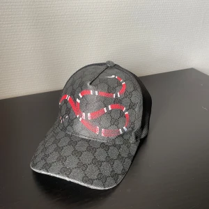Svart gg keps med orm mönster - Snygg svart gg keps med suverän passform och bekvämlighet, väldigt trendig och passar perfekt till vardagen 