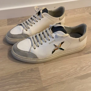 Axel Arigato clean 90 - Snygga vita sneakers från Axel Arigato med broderad fågel på sidan. Stl 41. Använda men i fint skick