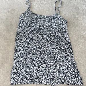 Kort leopardmönstrat linne - Snyggt linne med svartvitt leopardmönster och smala axelband. Perfekt för dig som vill sticka ut med ett djurmönster. Lätt och luftig känsla, passar till många olika stilar.