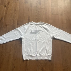 Nike Sweatshirt Vit - Säljer en vit Nike Sweatshirt i ett riktigt gott skick och väldigt snygg. Säljer den på grund av att den är för liten för mig. Skirv till mig vid funderingar.
