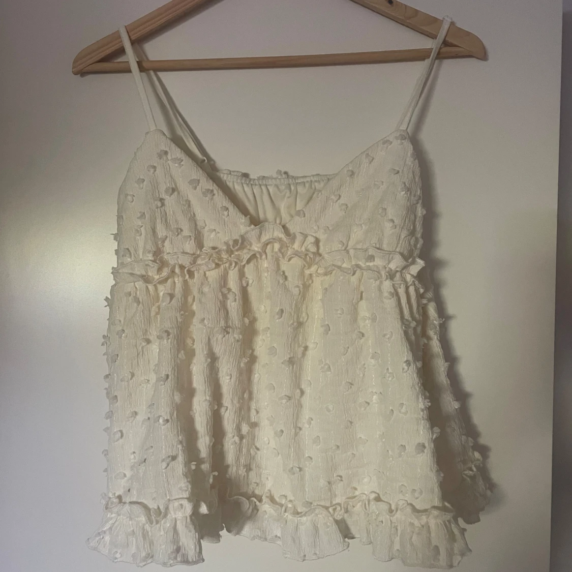 Krämvit volangig linnetopp 