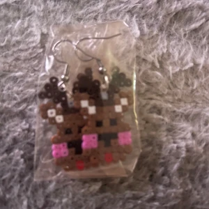 Söta renörhängen i pärlplattor - Unika örhängen med renmotiv gjorda av pärlplattor i brunt, rosa, svart, vitt och rött. Perfekta för att ge din stil en lekfull och julig touch. Hängande modell med metallkrok. Passar dig som vill sticka ut lite extra under vintern!