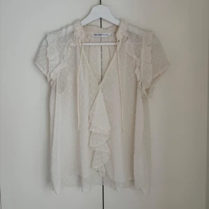 Topp från Zara - Supersöt topp från Zara i en storlek M men sitter mer som en S enligt min upplevelse. Superfint skick. Fina detaljer med volanger och spets.
