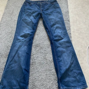 Levi’s bootcut jeans - Levis jeans i blå denim med bootcut passform. Lite slitna längst ner. De är insydda någon cm i midjan, se bild, men är enkelt att sprätta upp. Mått: midja 39, innerben 81