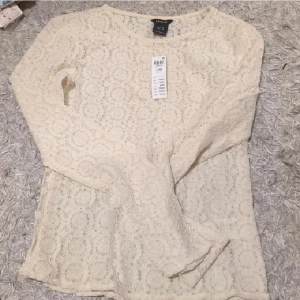 Spetsblus - Supersöt beige blus från Lindex i helspets med lång ärm och rund hals. Blusen har ett romantiskt uttryck med fina spetsdetaljer och är perfekt för dig som gillar en feminin stil. Passar till både jeans och kjol. (Fortfarande prislappen kvar 299)☺️