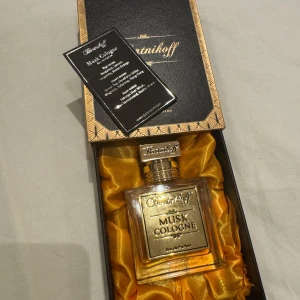 Bortnikoff Musk Cologne Parfym - Lyxig parfym från Bortnikoff i elegant fyrkantig glasflaska med guldfärgad etikett och lock. Levereras i svart och guld ask med guldfärgat sidenfoder. Doften är Musk Cologne, Eau de Parfum, och flaskan rymmer 50 ml.