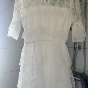 Vit spetsklänning från Bubbleroom - Superfin vit kortklänning från Bubbleroom med spetsdetaljer och volanger, säljer pga att den inte kommer till användning!💞
