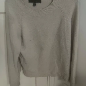 Beige stickad tröja från Vero Moda - En stilren beige stickad tröja från Vero Moda i storlek S. Tröjan har rund halsringning, långa ärmar och ribbade muddar vid hals, ärmslut och nederkant. Perfekt för lager-på-lager och enkel att matcha med jeans eller kjol.