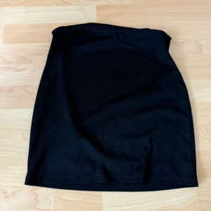 Svart kortkjol i bomull - Enkel svart kortkjol i mjukt bomullstyg. Klassisk rak modell som är lätt att matcha med olika toppar och jackor. Perfekt för dig som gillar en stilren och clean look.