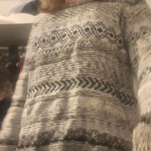 Mönstrad stickad tröja från H&M - Säljer en stickad tröja från H&M i svart, grått och vitt. Tröjan har ett snyggt mönster med olika geometriska former och är långärmad. Perfekt för dig som gillar en chill och mysig stil under kallare dagar.