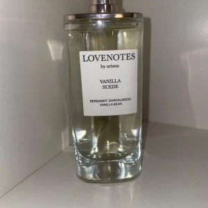 Lovenotes Vanilla Suede parfym - En stilren parfymflaska i genomskinligt glas med metallock. Doften Vanilla Suede har inslag av bergamott, sandelträ och vaniljböna. Flaskan har en minimalistisk vit etikett med svart text. Locket är tyvärr borttappat