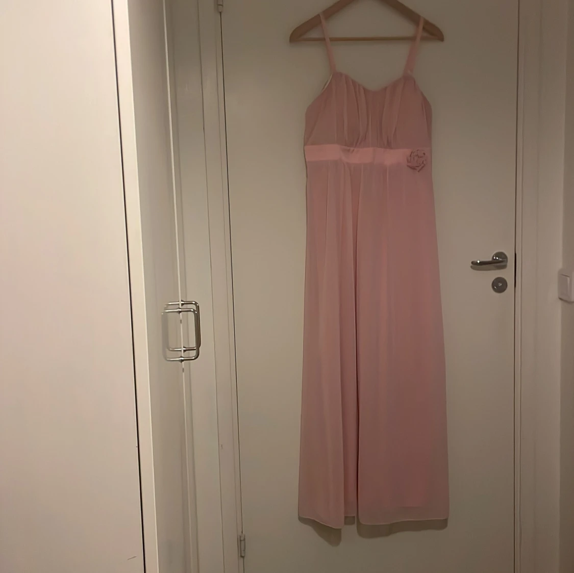 Ljusrosa långklänning med blomdetalj