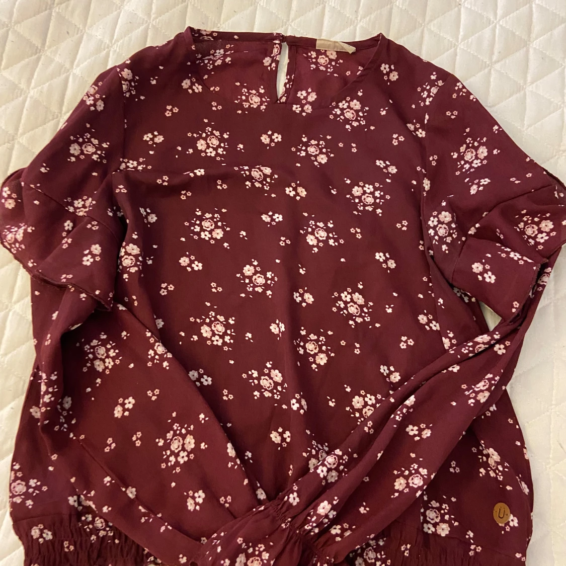 Vinröd blus med blommor i storlek 158