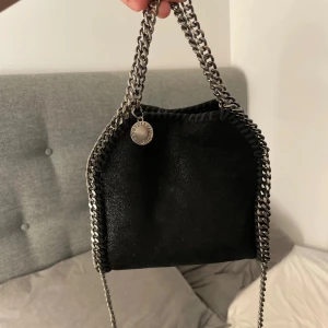 Stella Mccartney väska - Stella McCartney väska som är rätt så använd men det syns endast på insidan. Den är 16 cm vet ej vilken storlek det är. Har tyvärr tappat bort dustbagen i en flytt men tror att korten i väskan räknas som ett äkthetsbevis? Hör gärna av dig vid frågor! ☺️💕🫶