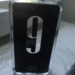 Afnan 9PM Eau de Parfum - Afnan 9PM är en stilren parfym i en rektangulär glasflaska med svart etikett och stora silverdetaljer. Flaskan har en modern och elegant design som sticker ut i parfymhyllan. Perfekt för dig som gillar unika och trendiga dofter.